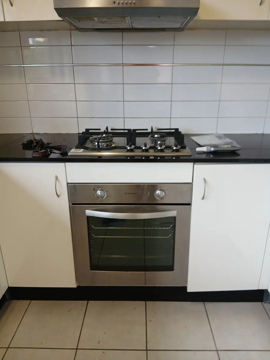 Gas cooktop and under-bench oven installed in a tiled kitchen