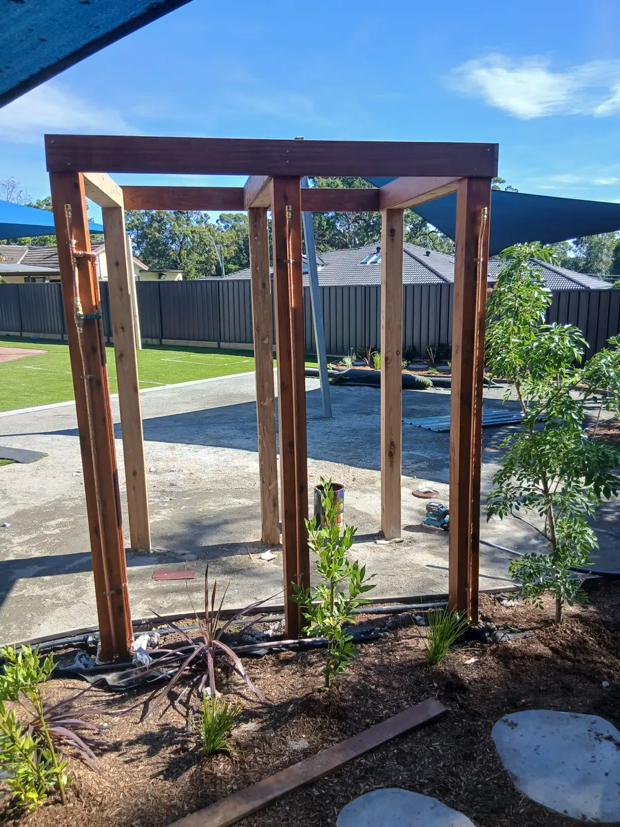 Timber pergola frame built over a paved backyard courtyard