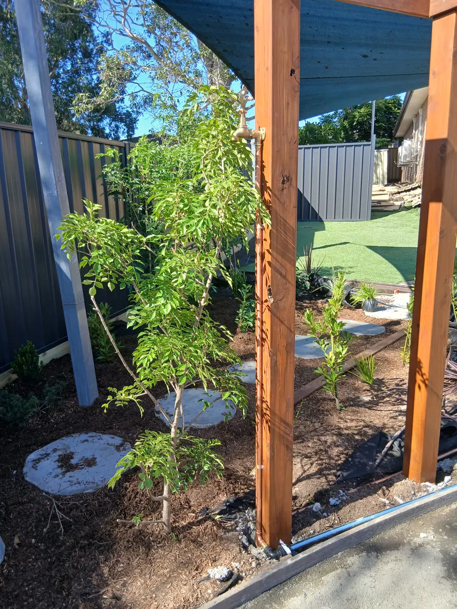 Freshly planted garden bed beside new timber pergola posts