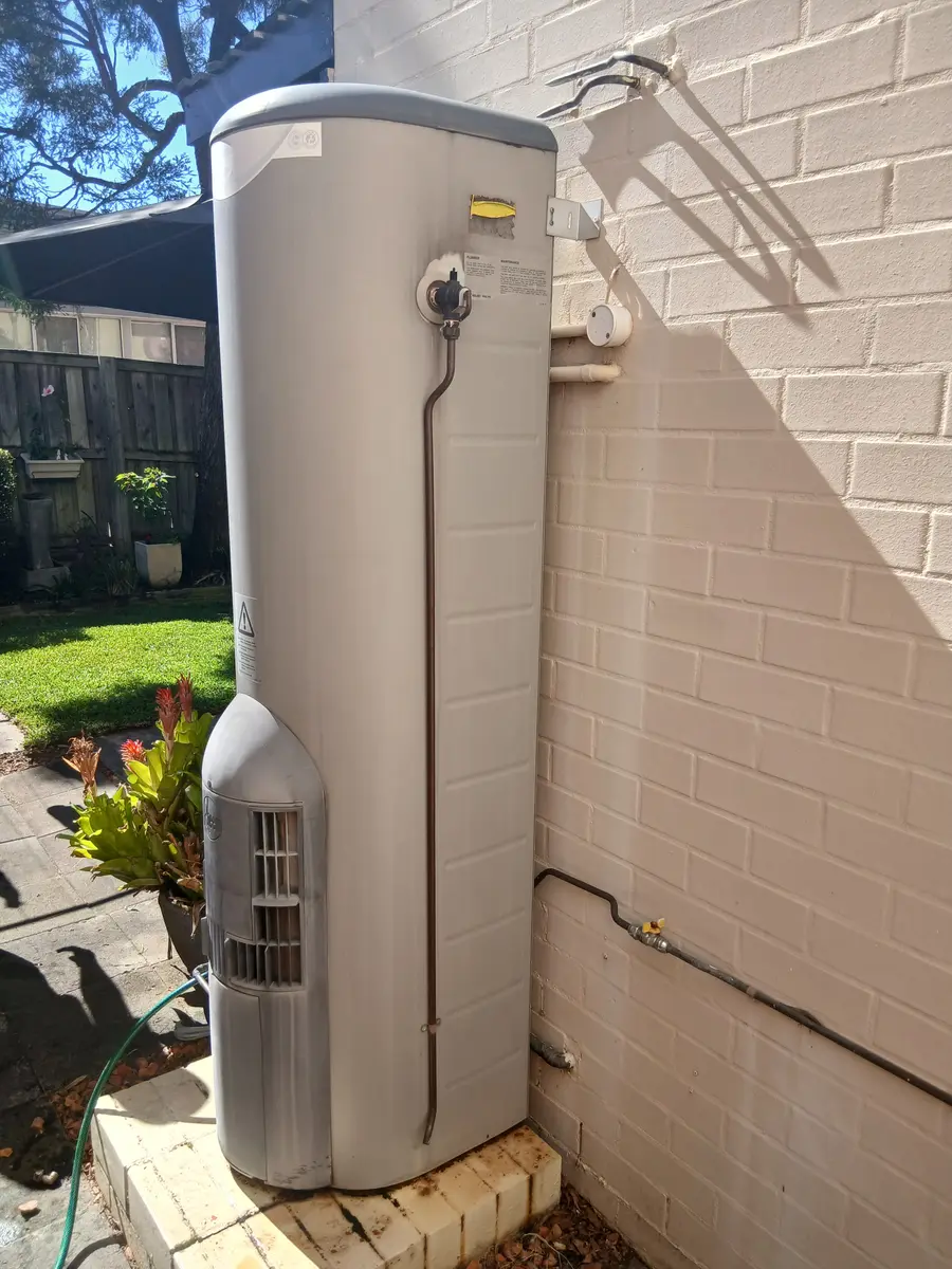 Large storage hot water system installed against a brick wall