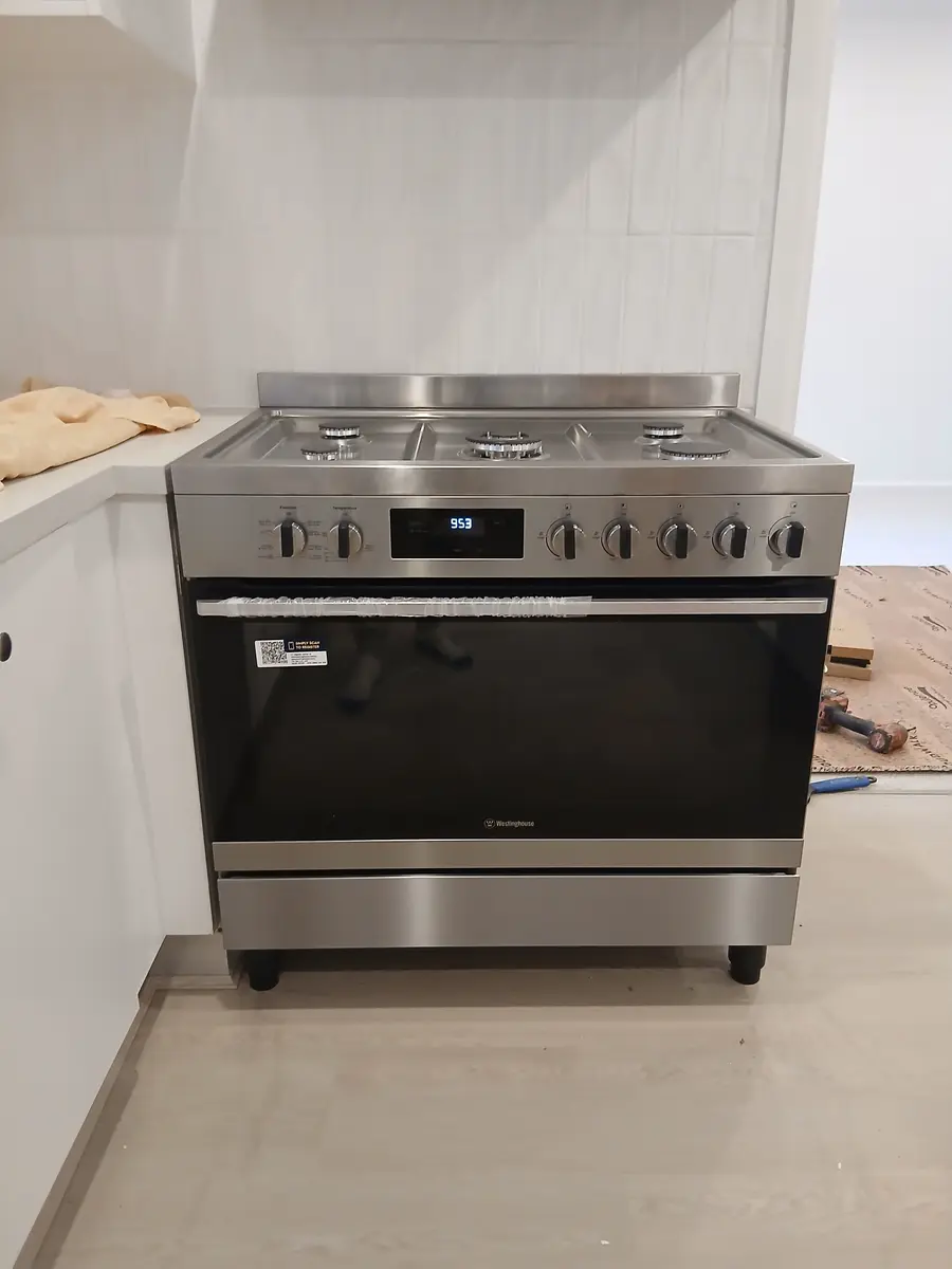 Freestanding stainless steel gas cooker installed in a new kitchen